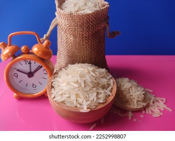 Concept of zakat. Selected focus rice in sack, bowl and clock. Zakat is obligatory for Muslims and is considered an act of worship to cleanse the property acquired in a certain period and count. - Shutterstock ID 2252998807