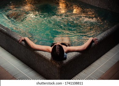 Conception of bodycare. Beauty and body care. View of a young woman enjoying whirlpool bath. Sensual young woman relaxing in spa hot tub.