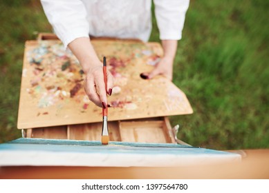 Conception of painting. Photo of woman's hand with red brush. - Powered by Shutterstock