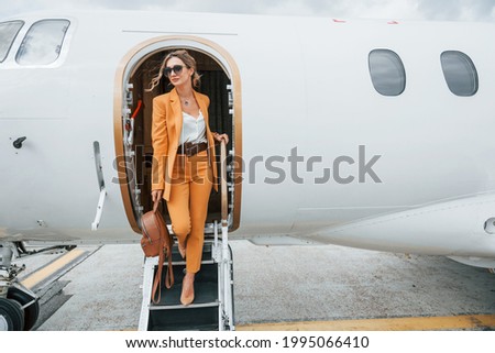 Conception of tourism. Passenger woman that is in yellow clothes and sunglasses.
