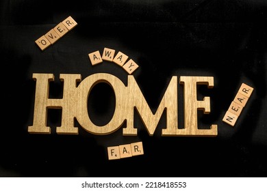A conceptional photo with three D wooden word, Home displayed with surrounding square wooden letters spelling out the words, over, away, far and near