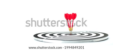 Concepts of business strategy and goals. Red darts embroidered on the Dartboard on white background. Dart in the bullseye.