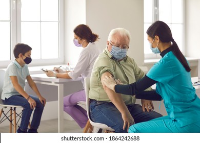 Concepts Of Immunization Campaign And Mass Vaccination. Professional Nurses Giving Injections To Old And Young Patients. Older Adults And Children Getting Flu Or Covid-19 Vaccines At The Hospital