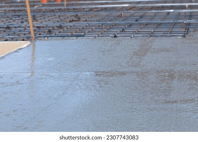 Concepts of pouring concrete screed. Powdered concrete over reinforcing mesh with clamps. - Shutterstock ID 2307743083