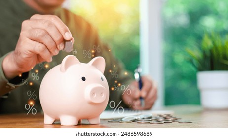 Concepts of saving money and financial planning. Man hand holding piggy bank on wood table, income, return, retirement, compensation fund, investment, dividend tax, stock market