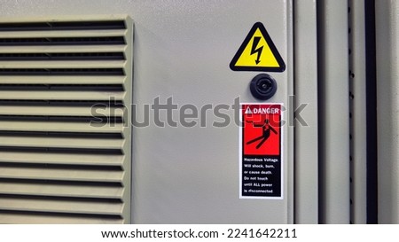 Concepts for work and workplace safety. Electric shock warning indicators mounted to the electric control cabinet warn of danger. Caution: use extreme caution when servicing electrical equipment