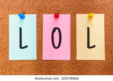 Conceptual 3 letters acronym abbreviation LOL (laughing out loud), a popular element of Internet slang, on multicolored stickers attached to a cork board. Casual Handwriting Concept