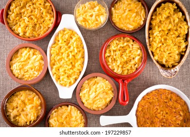 Conceptual Above View Of Cheese Macaroni Served In Different Types Of Cupson Brown Table Cloth