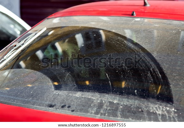 Conceptual\
background for car washes with dirty car glass, closeup rear window\
hatchback stained with dirt and\
dust.