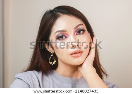 Conceptual beauty portrait of a beautiful young woman with colorful eyeshadow 