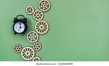 Conceptual black alarm clock with gears on green background. Time progress concept - Powered by Shutterstock