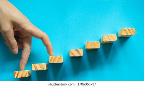 Conceptual Businessman Fingers Make Big Step On Wooden Blocks To Succes And Achievment By  Strategy(by Skip One).