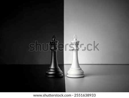 Conceptual composition with chess pieces in dramatic light, duality, good versus evil, darkness versus light, conflict.
