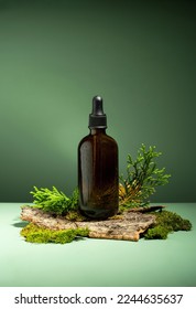 Conceptual composition of essential oils, moss and tree bark on a green background. Oil serum for skin and hair care. Glass bottles of body oil with a dropper. Self-care, Forest and nature theme. - Shutterstock ID 2244635637