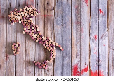 Conceptual Creative Map Of Italy, Sardinia And Sicily Formed Of Old Wine Corks In An Artistic Arrangement On An Old Wooden Counter Top With Copy Space , Overhead View