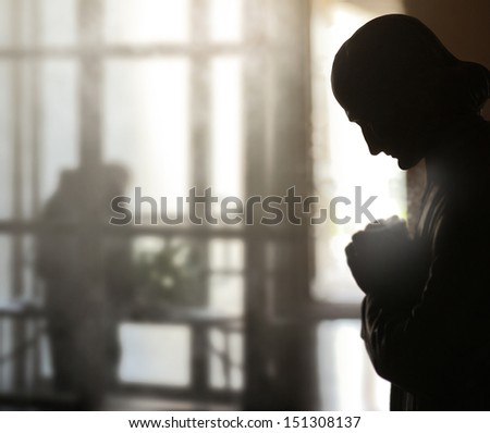 Conceptual fine art image of an interior with focus on statue of man praying