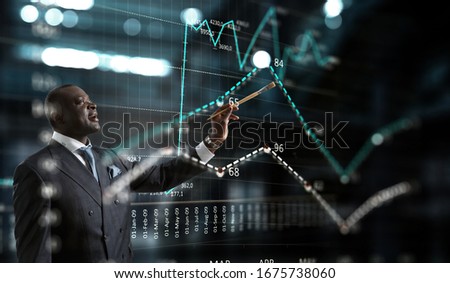 Conceptual image of ambitious and creative businessman in black suit holding paintbrush in hand