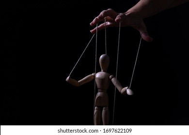 Conceptual image of a hand with strings on fingers to control a marionette
