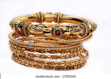 A Conceptual Image Of A Jeweled Bangle On The Top Of Other Bangles With Simple Pattern On A White Fabric, Depicting The Qualities Of A Leader.