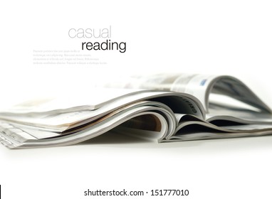 Conceptual image for marketing communications and advertising. High key studio image of glossy magazines against a white background with soft shadows. Copy space.