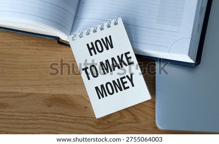 Conceptual image of a notebook with HOW TO MAKE MONEY text on a wooden office desk, representing financial growth, business strategy, and wealth creation.