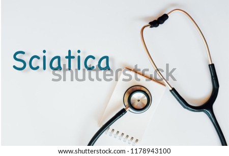 Conceptual image with Sciatica inscription with the view of stethoscope and notebook on the white background. Medical Conceptual. Copy space.
