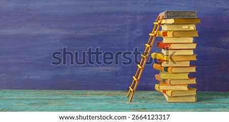Conceptual image of a stack of books with a ladder, idea, achievements, education, knowledge,academia and success concept.