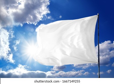 Conceptual Image Of Waving Blank White Flag Over Sunny Blue Sky