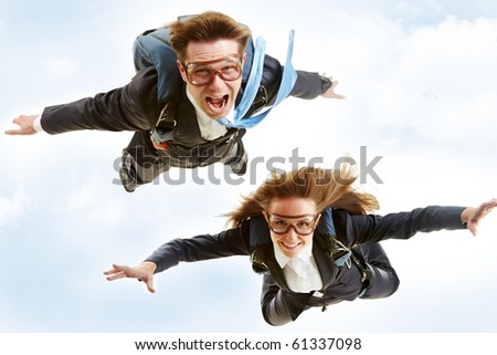 Conceptual image of young business partners flying with parachutes on their backs
