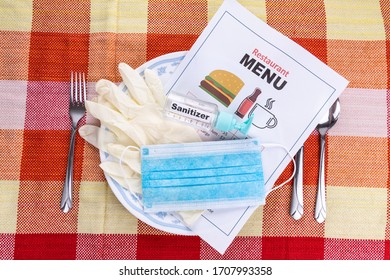 Conceptual Of The New Normal Lifestyle With Usage Of Sanitizer, Face Mask, Gloves And Disposable Menu At Restaurant Dining Table