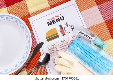 Conceptual Of The New Normal Lifestyle With Usage Of Sanitizer, Face Mask, Gloves And Disposable Menu At Restaurant Dining Table