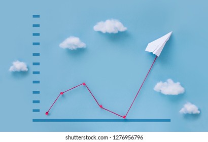 Conceptual Paper Plane Pulling Business Finance Growth Chart Line Upwards On Blue Sky Background. 