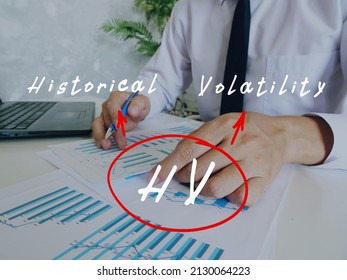Conceptual photo about HV Historical Volatility with written abbreviation. Business Man Checking Documents on background.