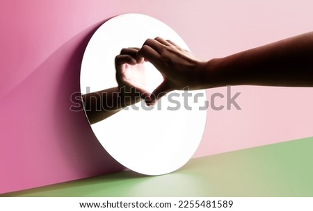 Conceptual Photo for Love and Relationship. Love Yourself. Single Person using Hand to Form a Heart Shape on the Mirror. Fill Yourself with Romance on Valentines Day