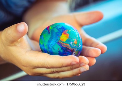 Conceptual Photo of a Saving the Planet, Babie's Hands Holding Little Earth, Made of Plasticine, Future of the Planet, Pollution Free. - Shutterstock ID 1759653023