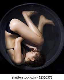 Conceptual Photo Of A Woman Curled Up In A Fetal Position In The Water.