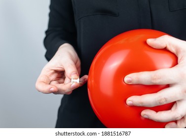 Conceptual Photography. The Woman Holds A Red Ball Near His Belly, Which Symbolizes Bloating And Flatulence. Then She Brings A Needle To It To Burst The Balloon And Thus Get Rid Of The Problem.
