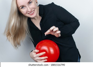 Conceptual Photography. The Woman Holds A Red Ball Near His Belly, Which Symbolizes Bloating And Flatulence. Then She Brings A Needle To It To Burst The Balloon And Thus Get Rid Of The Problem.