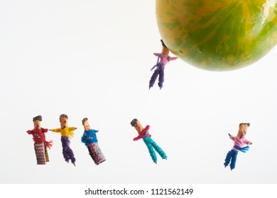 Conceptual Picture Using Worry Dolls And Tomato On White