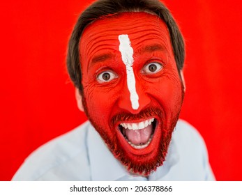 Conceptual Portrait Of Adult Man With Colorful Red Painted Face And White Line On Nose