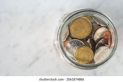 Conceptual Savings - Jar full of New Zealand Coins from Above with Copy Space