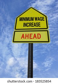 conceptual sign with words minimum wage increase  ahead over blue sky