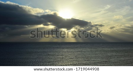 Conceptual sunset, with the sun blown out against a low key foreground.
   The spiritual and uplifting supernatural effect, of natural sun rays shining through the clouds.