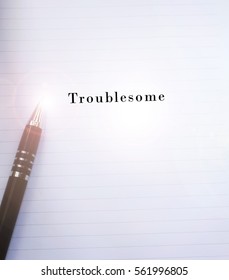 Conceptual,notebook on a white table. open diary and pen with TROUBLESOME words