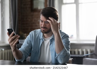 Concerned annoyed smartphone user man staring at cellphone screen with upset face, having problems with online app, banking service, getting bad news, feeling stress about poor connection