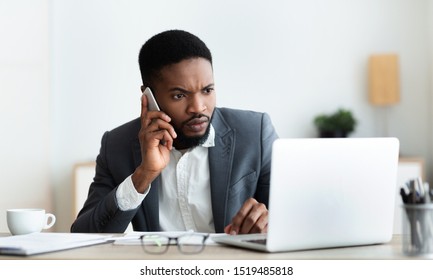 Concerned Businessman Talking On Cell Phone And Looking At Laptop Screen, Trying To Reach Technical Support To Solve Issue With His Computer, Panorama