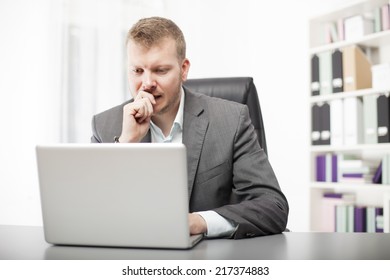 Concerned Businessman Working At His Desk In The Office Staring At The Screen Of His Laptop Computer With A Worried Expression