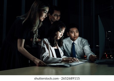 Concerned fintech team analyzing data on screen during late night meeting. Represents pressure, critical decision making, and teamwork in financial technology environment.