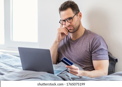 Concerned Man Holding Credit Card Shopping Online On Laptop Having No Money At Home. Online Payment, Bank Account Problem. - Shutterstock ID 1765075199