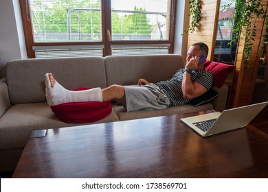 Concerned Man Talking On Mobile Phone lies At Laptop On Sofa Indoor. Business Calls Concept. - Powered by Shutterstock